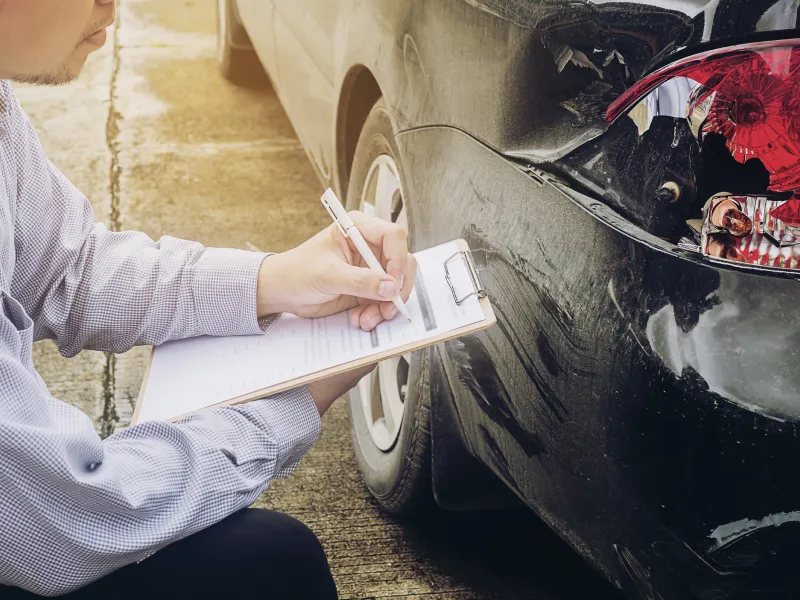 車をみて記入する作業員